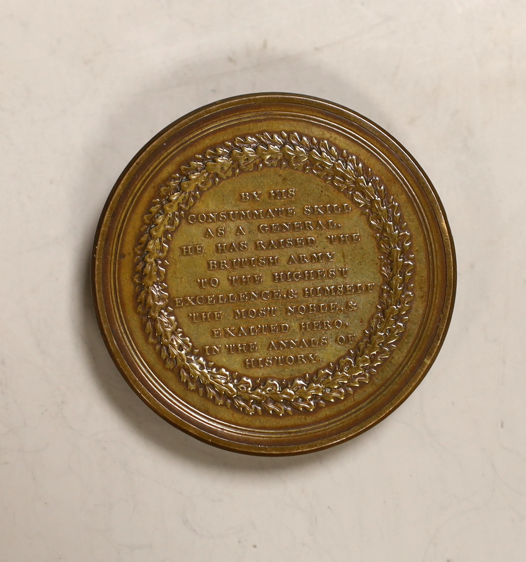 A cylindrical box formed in the shape of a coin commemorating The Duke of Wellington's Continental Victories, 4.7cm